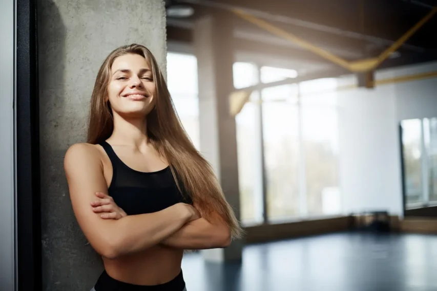 mulher fitness feliz de braços cruzados e não tem dúvidas do porque do hipecalórico caseiro